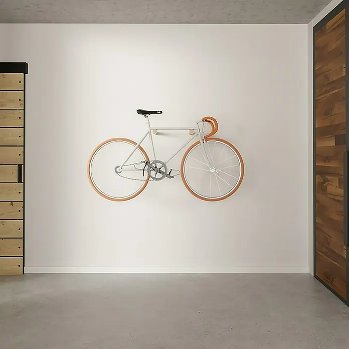 Rei Fahrradhalterung - Länge: 310 mm, 2 Stk. - Ein modernes, weißes Fahrrad mit braunen Reifen hängt an einer weißen Wand und sorgt für einen minimalistischen Look.