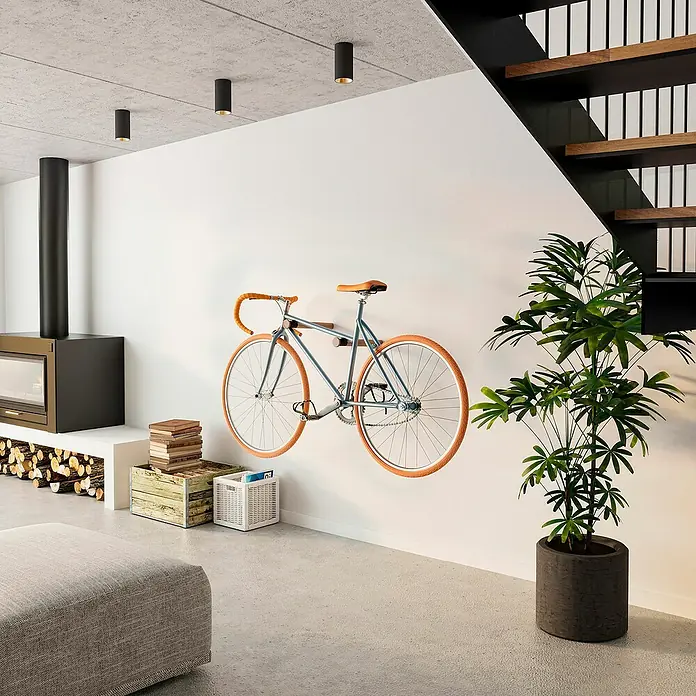 Rei Fahrradhalterung - Länge: 390 mm, 2 Stk. - An der Wand montiertes Fahrrad im modernen Wohnzimmer, ergänzt durch eine Zimmerpflanze und einen Kamin.