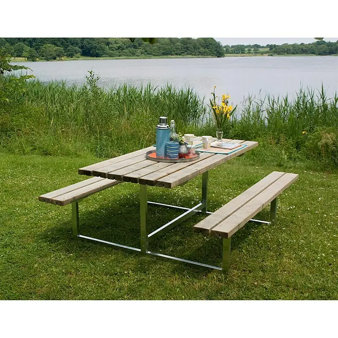 Plus Picknicktisch Basic - Natur, Kiefer/Fichte & Stahl, 6 Personen, ohne Rückenlehne - Ein rustikaler Picknicktisch mit Bänken in einer malerischen Landschaft, ideal für Mahlzeiten im Freien und entspannte Stunden in der Natur.