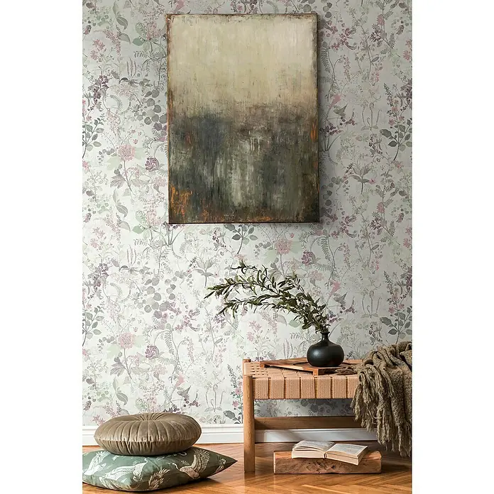 A.S. Création Vliestapete Blüten - Pastell, Floral, 10,05 x 0,53 m - Einrichtung mit einem Gemälde, einem Holzhocker mit Decke, einer Vase mit Grünzeug und Kissen auf einem Parkettboden.