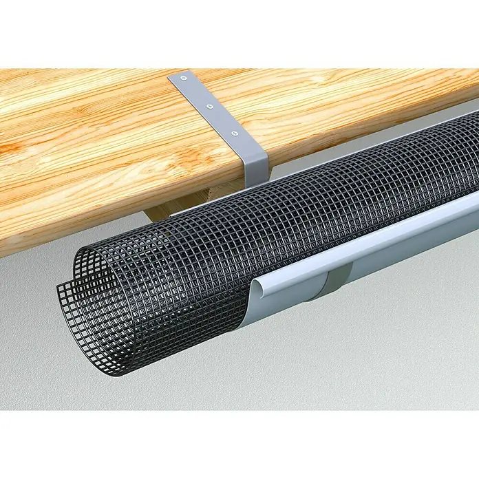 FunkeGruppe Laubfanggitter - Nennweite Zubehör Dachrinnen: 100 - 125 mm, Länge: 200 cm - Nahaufnahme einer Dachrinne mit einem schwarzen Gittereinsatz, der vor Laub schützt, befestigt an einem hellen Holzdach mit Halterungen.