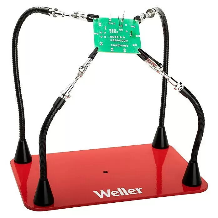 Weller Löthilfe WLACCHHM-02 - Geeignet für: Lötarbeiten - Weller Lötstation mit rotem Sockel, vier flexiblen schwarzen Armen und silbernen Krokodilklemmen, die eine grüne Platine halten.