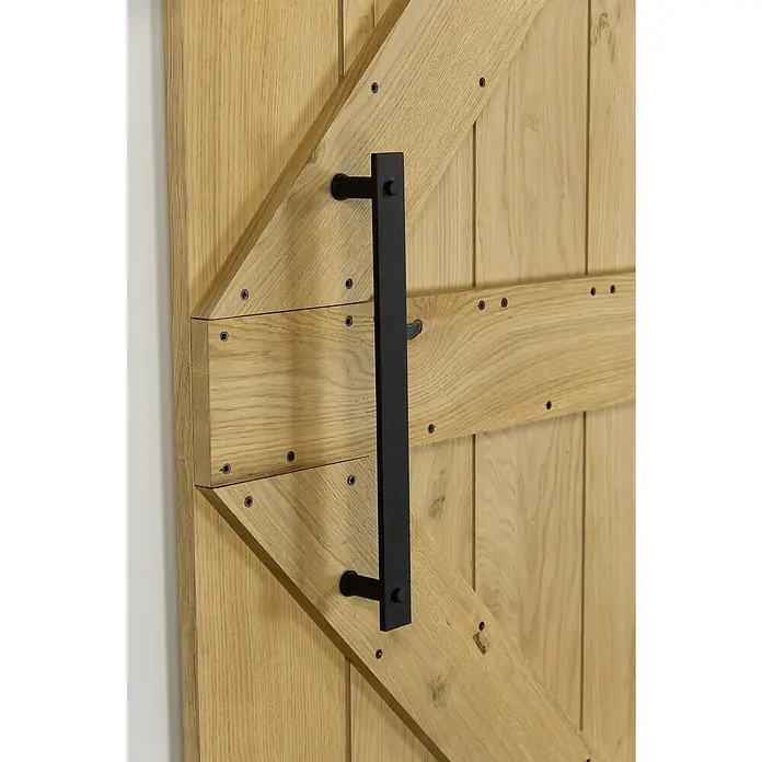 Radex Griffstangenpaar - 365 x 45 x 30 mm, Stahl, Schwarz matt - Detailaufnahme einer Holztür mit einem schwarzen, rechteckigen Türgriff. Der Türgriff ist ein markantes Gestaltungselement.