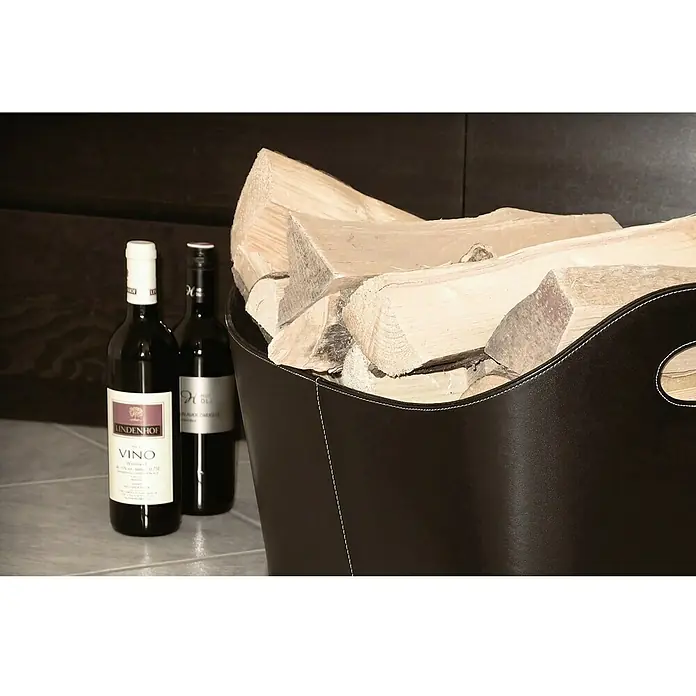 Lienbacher Cesto de cuero para la leña - L x An x Al: 55 x 40 x 35 cm, Cuero artificial, Negro - Primer plano de una cesta de leña de cuero llena de leña, con dos botellas de vino al lado, ideal para noches acogedoras.