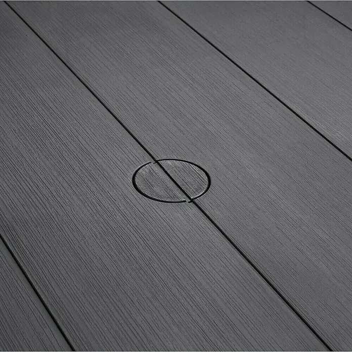 Keter Mesa de jardín Julie - L x An x Al: 149 x 92 x 75 cm, Polipropileno, Grafito - Primer plano de tablas de tarima gris con una cubierta circular. La textura de la tarima es claramente visible.