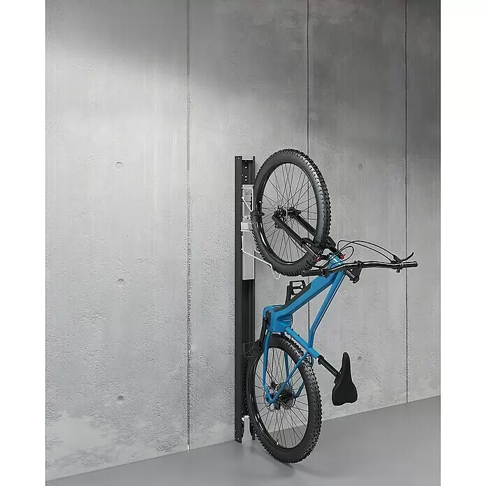 Biohort Fahrradlift Wandmontage - Nicht schwenkbar, Dunkelgrau-metallic - Ein blaues Fahrrad steht senkrecht an einem schwarzen Wandhalter an einer Betonwand, um Platz zu sparen.