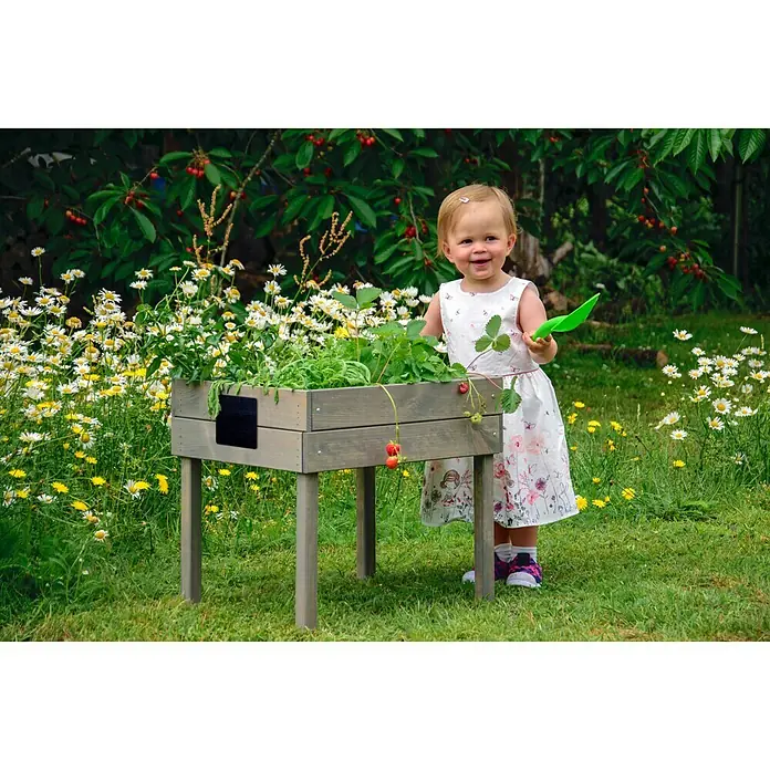 Dobar Hochbeet - 50 x 40 x 45 cm, Holz, Grau - Ein erhöhtes Gartenbeet aus Holz mit einem kleinen Mädchen, das einen grünen Spaten hält, ideal für Kinder zum Gärtnern.