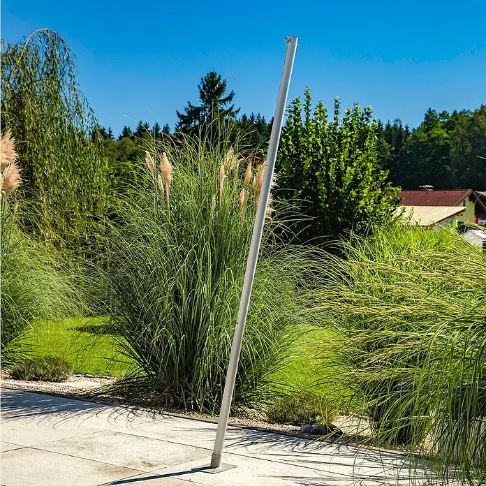Windhager Sonnensegelmast - Höhe: 240 cm - Eine schräg stehende, silberne Stange vor einem Hintergrund aus üppigem, grünem Gras unter strahlend blauem Himmel.