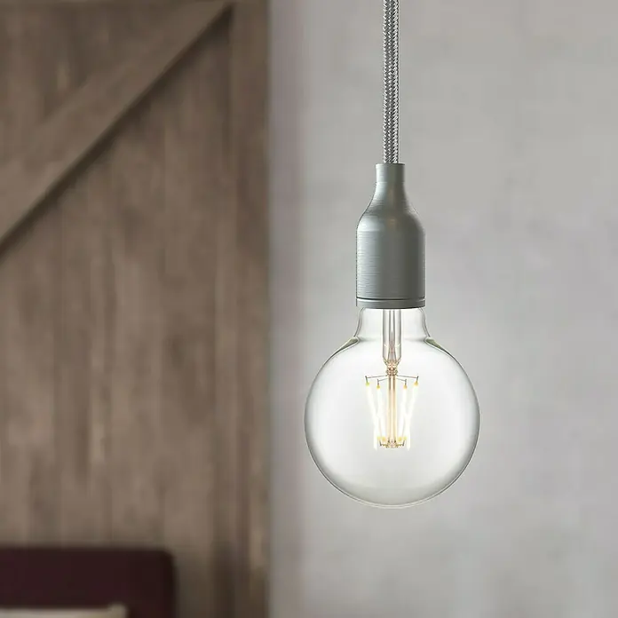 Home Sweet Home LED-Lampe Vintage Globe-Form E27 - E27, Dimmbar, Neutralweiß, 350 lm, 4 W, Farbe: Klar - Nahaufnahme einer klaren Glühbirne mit silbernem Lampensockel und geflochtenem Kabel.