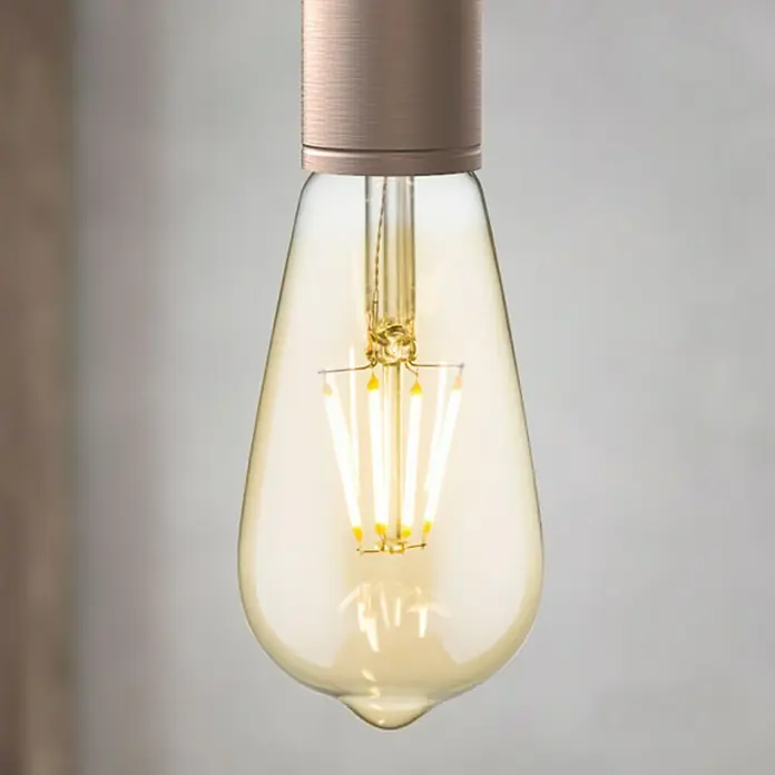 Home Sweet Home LED-Lampe Vintage Glühlampenform E27 - E27, Dimmbar, Warmweiß, 330 lm, 4 W - Nahaufnahme einer Retro-LED-Glühbirne, die warmes, bernsteinfarbenes Licht ausstrahlt und ein dekoratives Element für Vintage-Beleuchtung bietet.