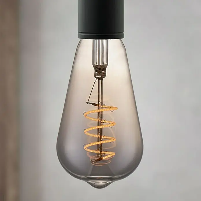 Home Sweet Home LED-Lampe Vintage Glühlampenform E27 - E27, Dimmbar, Warmweiß, 20 lm, 4 W, Farbe: Smoky - Nahaufnahme einer Edison-Glühbirne mit spiralförmigem Glühfaden und rauchfarbenem Glas, die ein warmes, dekoratives Licht ausstrahlt.