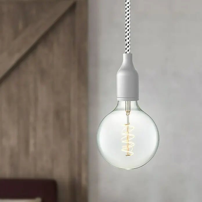 Home Sweet Home LED-Lampe Vintage Globe-Form E27 - E27, Dimmbar, Neutralweiß, 160 lm, 4 W - Nahaufnahme einer runden Glühbirne mit spiralförmigem Glühfaden und weißer Fassung, die an einem schwarz-weiß gemusterten Kabel hängt.