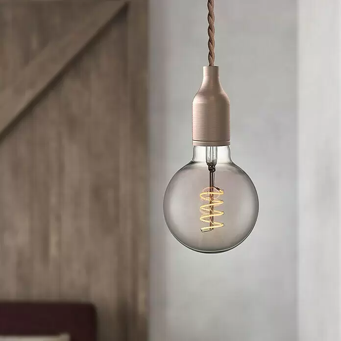 Home Sweet Home LED-Lampe Vintage Globe-Form E27 - E27, Dimmbar, Warmweiß, 140 lm, 4 W, Farbe: Smoky - Hängende Deko-Glühbirne mit Rauchglas, sichtbarem Spiralfaden, kupferfarbener Fassung und geflochtenem braunem Textilkabel, beleuchtet in einem Raum.