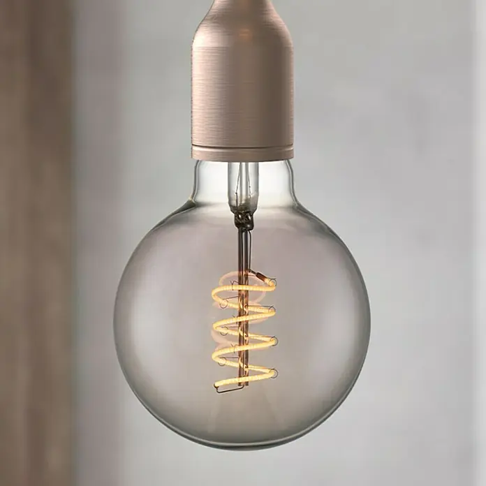 Home Sweet Home LED-Lampe Vintage Globe-Form E27 - E27, Dimmbar, Warmweiß, 140 lm, 4 W, Farbe: Smoky - Nahaufnahme einer dekorativen Edison-Glühbirne mit spiralförmigem Glühfaden und bronzefarbenem Sockel, die warmes Licht ausstrahlt.
