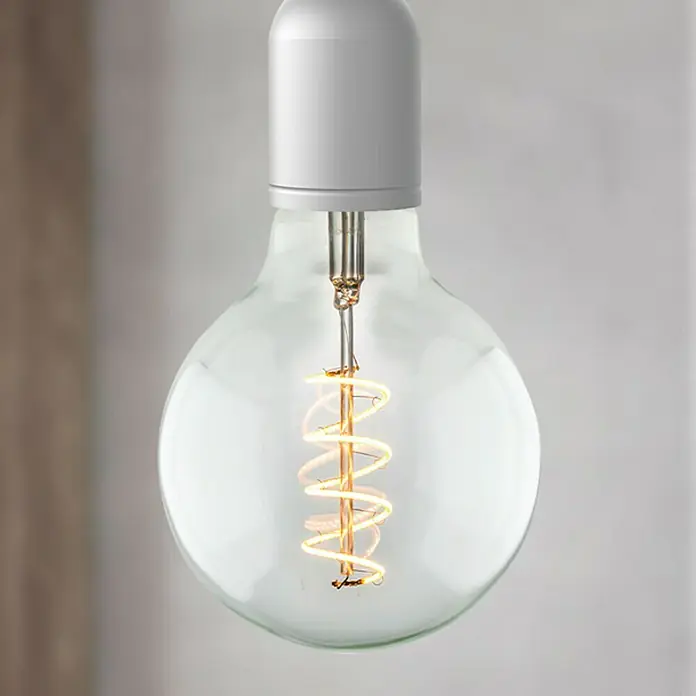Home Sweet Home LED-Lampe Vintage Globe-Form E27 - E27, Dimmbar, Neutralweiß, 280 lm, 4 W, Farbe: Klar - Nahaufnahme einer Vintage-Glühbirne mit einer spiralförmigen Glühwendel, die warmes Licht ausstrahlt, ideal für stimmungsvolle Beleuchtung.