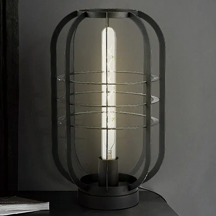 Home Sweet Home LED-Lampe Vintage Globe-Form E27 - E27, Dimmbar, Neutralweiß, 350 lm, 5 W, Farbe: Klar - Nahaufnahme einer Tischleuchte im Industrie-Stil mit einem länglichen, freiliegenden Leuchtmittel und einem schwarzen Metallkäfig.