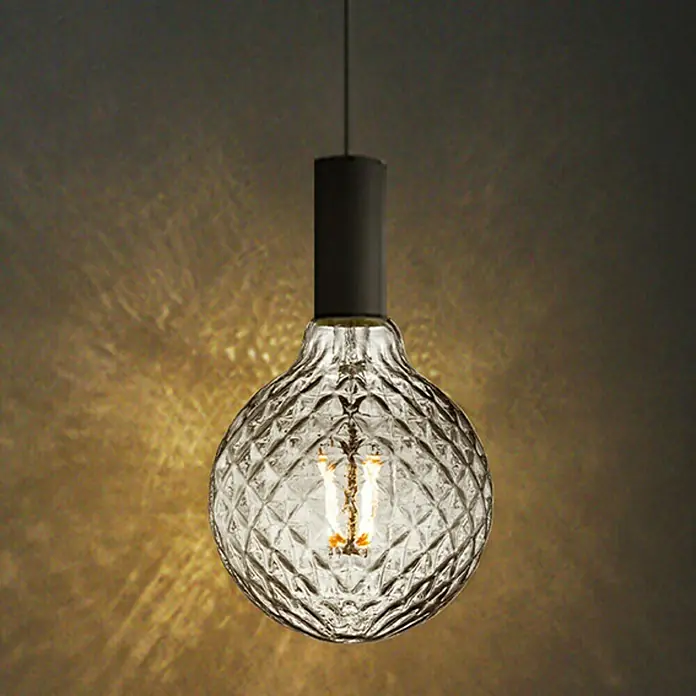 Home Sweet Home LED-Lampe Vintage Globe-Form E27 - E27, Dimmbar, Warmweiß, 40 lm, 4 W - Nahaufnahme einer dekorativen Glühbirne mit Kristallmuster, die ein warmes Licht ausstrahlt.