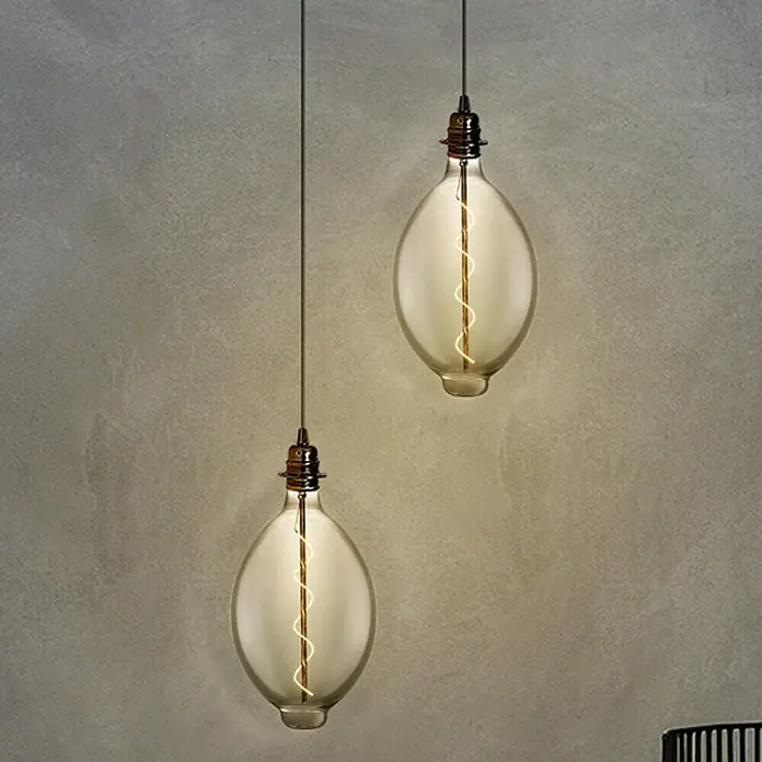Home Sweet Home LED-Lampe Vintage Globe-Form E27 - E27, Dimmbar, Warmweiß, 20 lm, 4 W - Zwei hängende, birnenförmige Glühbirnen mit einem warmen, gelblichen Schein vor einem strukturierten, grauen Hintergrund.