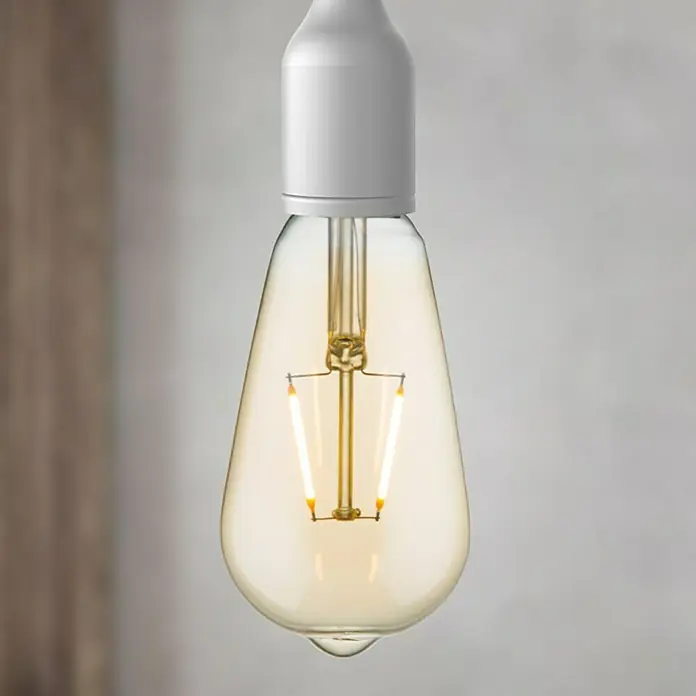 Home Sweet Home LED-Lampe - E27, Nicht Dimmbar, Warmweiß, 160 lm, 2 W, Farbe: Gold - Nahaufnahme einer Edison-Glühbirne mit klarem Glaskörper und Glühfaden, die ein warmes Licht ausstrahlt.