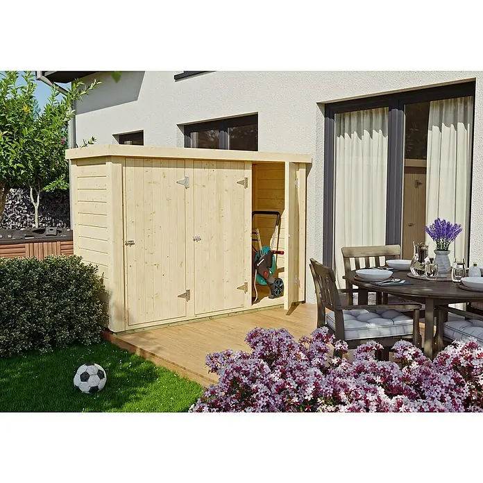 Geräteschrank Rauma - Außenmaß inkl. Dachüberstand (B x T): 244 x 94 cm, Holz, Natur - Ein geräumiger Holzschuppen mit Doppeltüren steht auf einer Terrasse und bietet viel Stauraum für Gartengeräte und andere Outdoor-Utensilien.