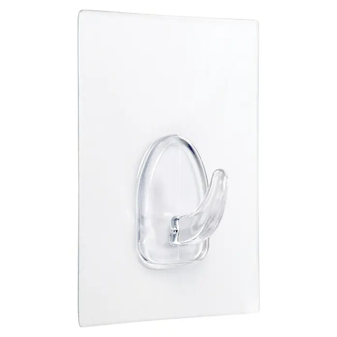 Inofix Colgador adhesivo 1291 - L x An x Al: 80 x 62 x 21 mm, Plástico, Transparente - La imagen muestra un gancho adhesivo transparente en una pared blanca, ideal para soluciones de almacenamiento fáciles.