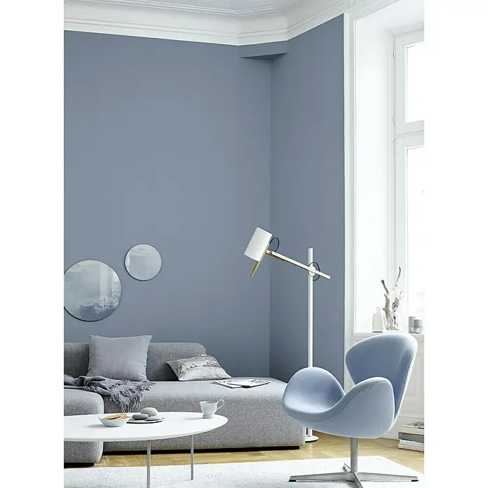 Alpina Wandfarbe Feine Farben - Ruhe des Nordens, Matt, 2,5 l, Konservierungsmittelfrei - Modernes Wohnzimmer mit grauem Sofa, blauem Sessel und weißem Couchtisch, beleuchtet durch eine Stehlampe.