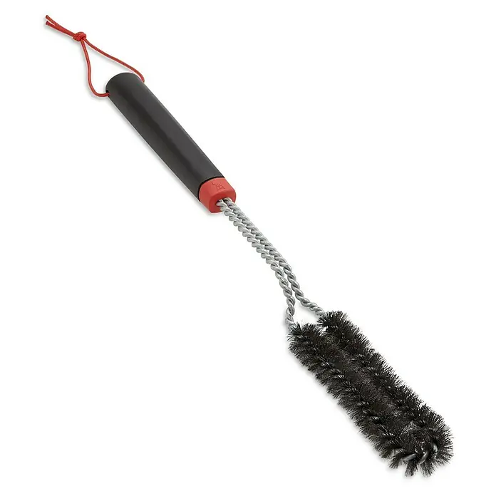Weber Grillbürste - Länge: 44,5 cm - Eine Grillbürste mit schwarzem Griff und Borsten, verbunden durch ein silbernes Drahtgeflecht, hängt vor einem dunklen Hintergrund.