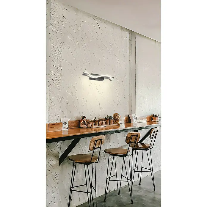 Fischer & Honsel LED-Wandleuchte - 8 W, L x B x H: 144,5 x 21 x 21 cm, schwarz matt, Warmweiß - Wandleuchte in modernem Design über einer Bar mit Hockern und Dekorationen.
