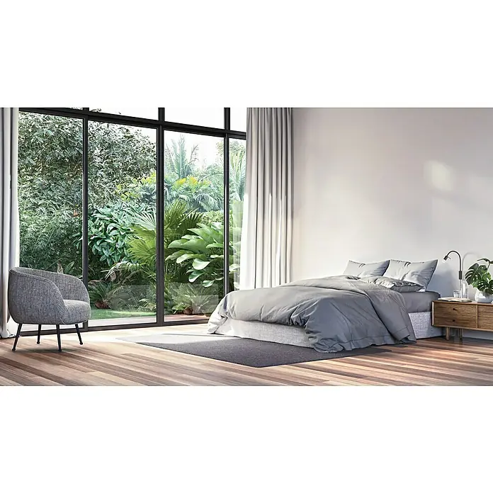 Fischer & Honsel LED-Wandstrahler Seng - 4,5 W, Sandschwarz, Warmweiß - Zimmer mit großem Fenster und Naturlandschaft. Das graue Bett mit dem Nachttisch und der graue Sessel laden zum Verweilen ein.