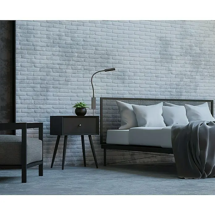 Fischer & Honsel LED-Wandstrahler Raik - 5 W, schwarz matt, Warmweiß - Elegantes Schlafzimmer-Interieur mit einem stilvollen Nachttisch, einer modernen Lampe und einem bequemen Bett vor einer Backsteinwand.