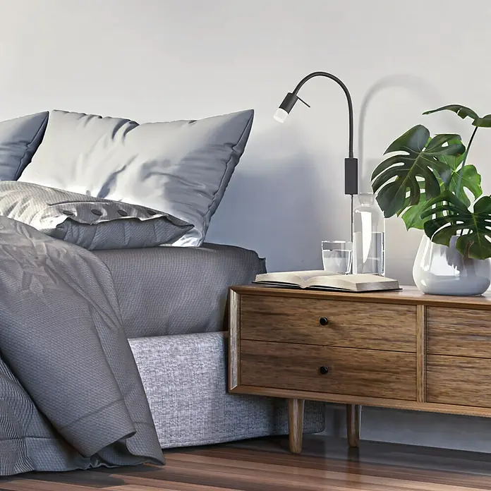 Fischer & Honsel LED-Wandstrahler Seng - 4,5 W, Sandschwarz, Warmweiß - Elegantes Schlafzimmer-Arrangement mit einem Nachttisch aus Holz, einer Lampe, einem Buch und Zimmerpflanzen, die eine entspannende Atmosphäre schaffen.