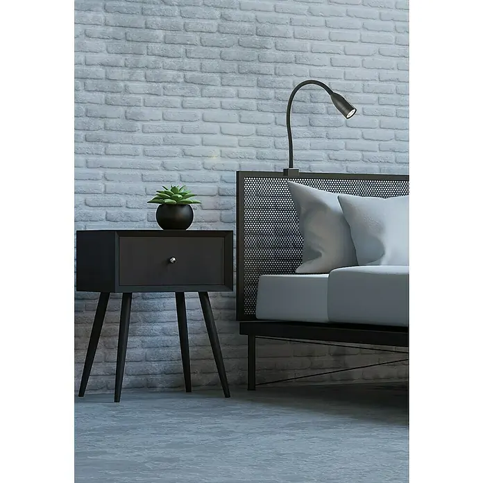 Fischer & Honsel LED-Wandstrahler Sten - 5 W, L x B x H: 40 x 35 x 11 cm, schwarz matt, Warmweiß - Nahaufnahme eines Nachttisches mit einer Sukkulente und einem Bett mit Leselampe, alles vor einer Backsteinmauer.