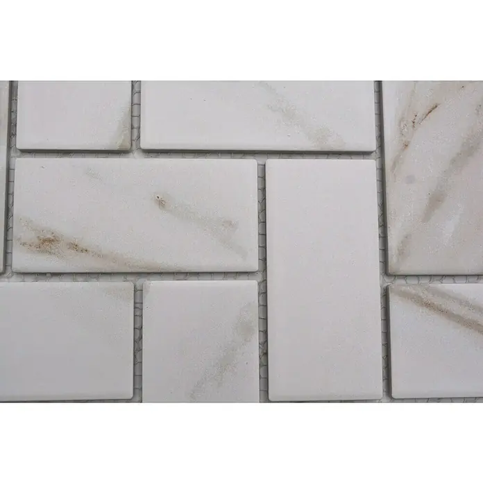 Mosaikfliese Fischgrät Calacatta CIM HB CT - 27,9 x 27,4 cm, Weiß, Matt - Nahaufnahme von eleganten weißen Marmorfliesen mit einzigartigen Maserungen, die eine raffinierte Textur und zeitlose Ästhetik bieten.