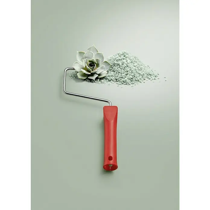 SCHÖNER WOHNEN-Farbe Wandfarbe Trendfarbe Limited Collection - Spa, Matt, 1 l, Konservierungsmittelfrei - Eine Nahaufnahme eines Farbauftragrollers mit einem roten Griff, einer Sukkulente und einer grünen Granulathäufung auf hellgrünem Hintergrund.