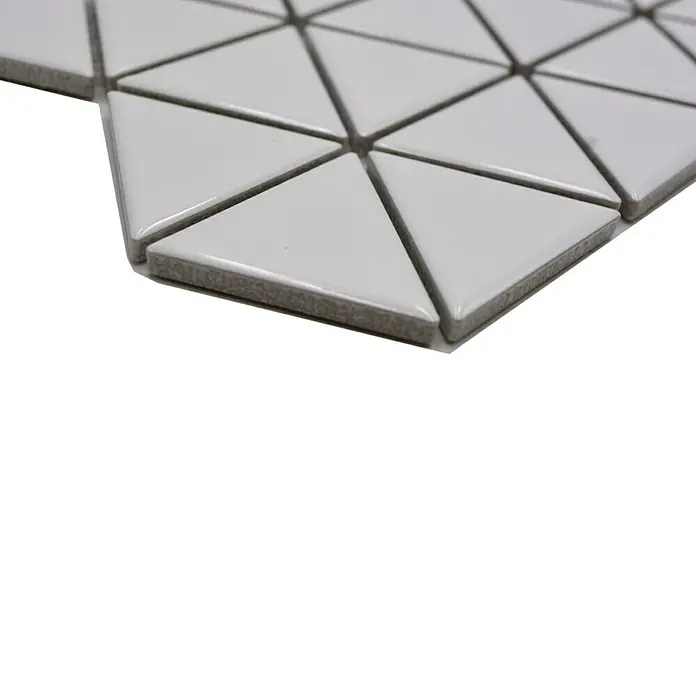 Mosaikfliese Dreieck Uni CG TR 51 - 29,1 x 25,2 cm, Weiß, Glänzend - Nahaufnahme von dreieckigen, weißen Keramikfliesen mit grauen Fugen, die ein geometrisches Muster bilden und eine moderne Ästhetik erzeugen.