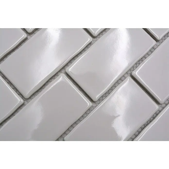 Mosaikfliese Subway Handmade Style HSS 238 - 30,9 x 26,5 cm, Weiß, Glänzend - Nahaufnahme von glänzenden, rechteckigen weißen Keramikfliesen im Fischgrätmuster, ideal für moderne Wand- und Bodengestaltungen.