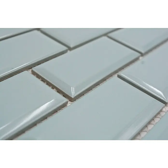 Mosaikfliese Metro Uni CG M17MG - 29,1 x 29,6 cm, mintgrün, Glänzend - Nahaufnahme von hellblauen rechteckigen glänzenden Ziegeln, die im Mauerverband verlegt sind und ein sauberes und modernes Design zeigen.