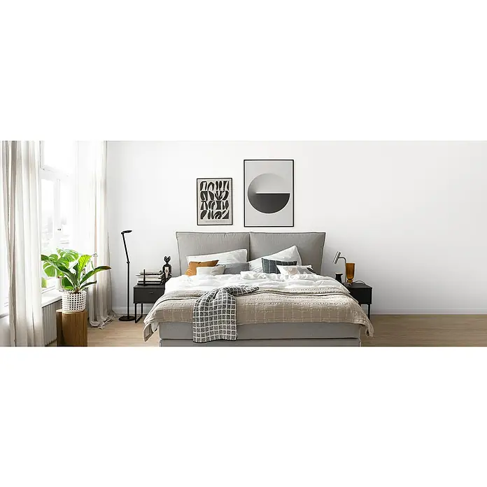 SCHÖNER WOHNEN-Farbe Naturell Wandfarbe Lehmfarbe - Weiß, Matt, 10 l, Konservierungsmittelfrei - Einladendes Schlafzimmer mit einem Kingsize-Bett, zwei Postern und Nachttischen. Die Farbpalette ist neutral, mit Akzenten in Schwarz, Weiß und Holz.