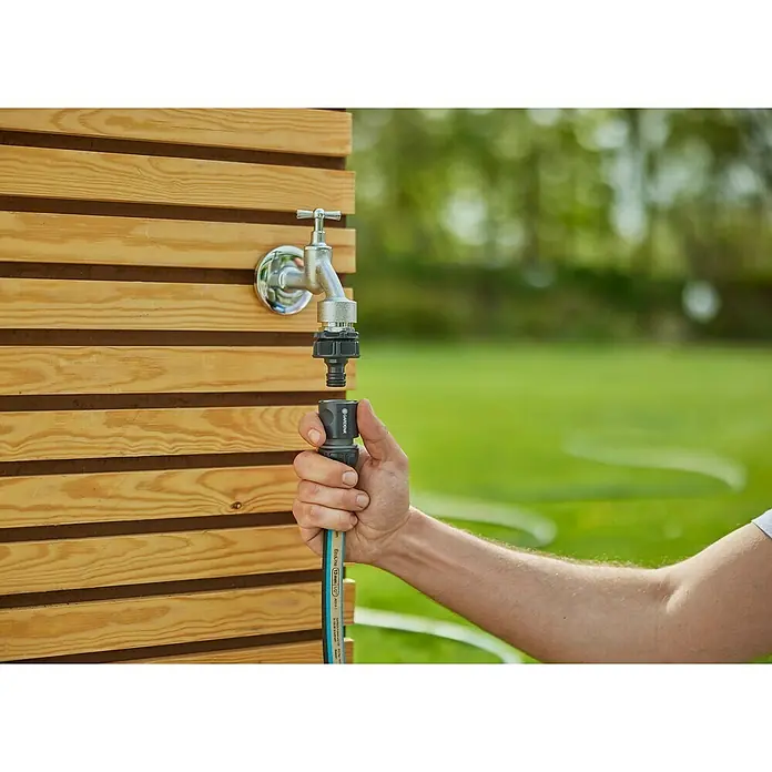 Gardena EcoLine Gartenschlauch - 20 m - Eine Hand verbindet einen Gardena-Schlauch mit einem Wasserhahn. Ideal für Gartenbewässerung und einfache Installation.