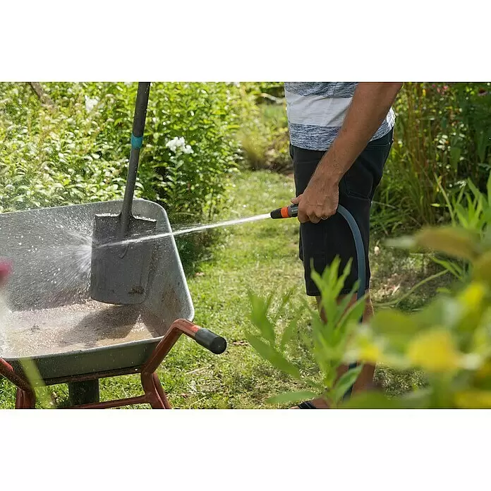 Gardena Gartenschlauch Liano Life Set - 30 m, Schlauchdurchmesser: 13 mm - Eine Person reinigt eine Schaufel in einer Schubkarre mit einem Gartenschlauch.