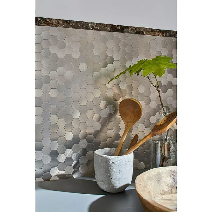 Selbstklebemosaik Hexagon SAM 4MMHX - 28 x 29 cm, Silber, Matt - Nahaufnahme von sechseckigen Edelstahlfliesen mit Holzlöffeln und Pflanze in der Küche.