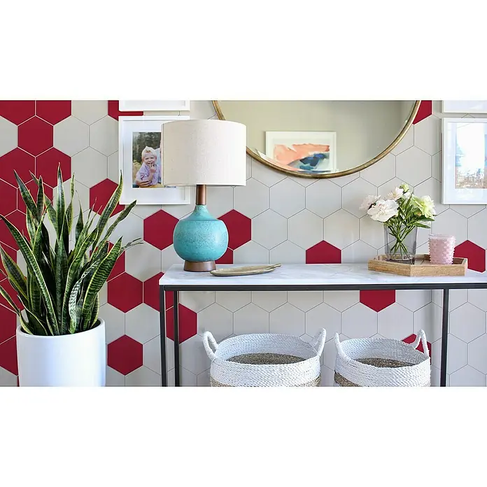 Selbstklebemosaik Hexagon Uni SAMT CHA1R - 15,2 x 17,2 cm, Rot, Matt - Nahaufnahme eines Eingangs mit einer Konsole mit Lampe, Vase und Pflanze vor einer sechseckigen Wand.