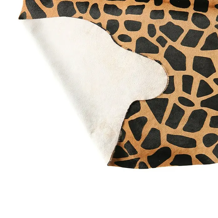 Esbeco Kuhfell - 100 % Echtfell, Giraffe - Nahaufnahme eines Stücks Tierfell mit Giraffenmuster, die Rückseite ist hell und rau.
