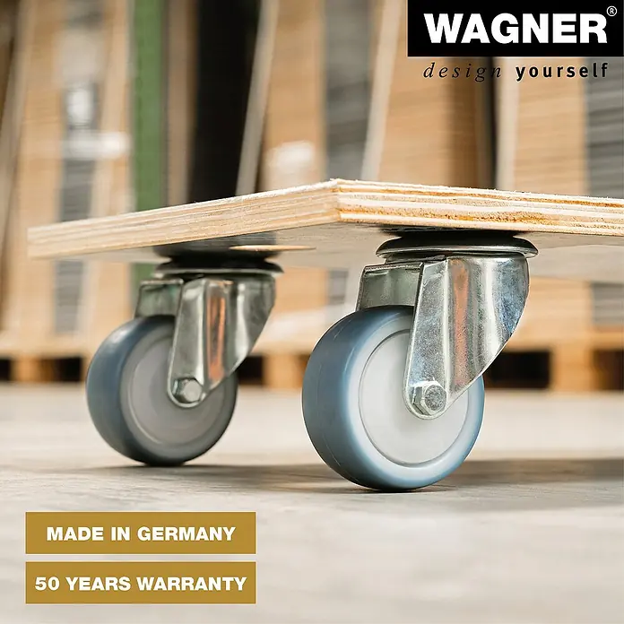 Wagner System Transportroller MM1085 - L x B x H: 300 x 575 x 120 mm, Traglast: 400 kg, Holz - Bild einer Möbelrolle von Wagner, die an einer Holzplatte befestigt ist. Die Rolle ist grau und hat ein silbernes Gehäuse.