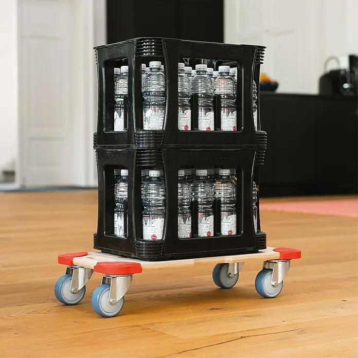 Wagner System Transportroller MM1322 - L x B x H: 590 x 290 x 110 mm, Traglast: 300 kg, Holz - Getränkekisten auf einem Rollbrett. Die Kisten sind mit Wasserflaschen gefüllt und stehen auf einem hölzernen Rollbrett mit blauen Rädern.