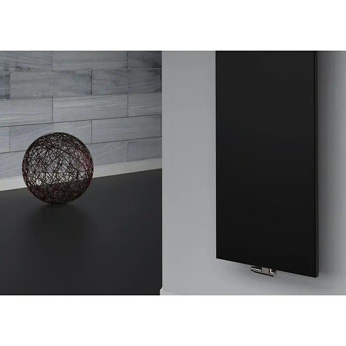 Szagato Designheizkörper Manhattan 2 - B x H: 470 x 1.200 mm, Wärmeleistung bei Vorlauftemperatur von 75 °C (D: 50): 799 W, Schwarz, Ohne Handtuchhalter - Ein moderner, schwarzer Paneelheizkörper an einer grauen Wand, neben einer dekorativen Kugel, ideal für stilvolle Raumgestaltung.