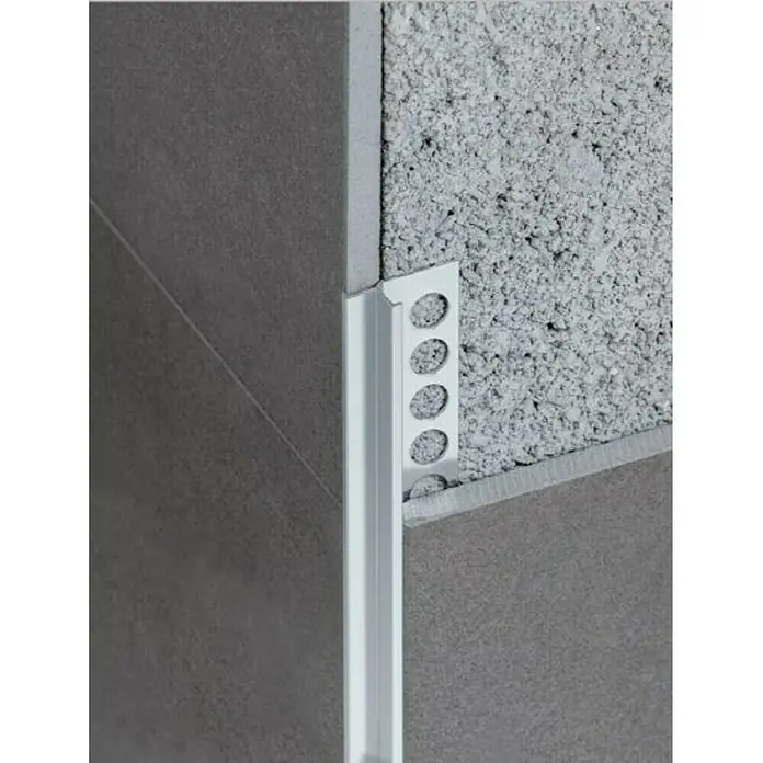 Perfil para baldosas Eurocanto 150A - Aluminio, Plateado, 2,5 m x 10 mm, Brillante - Detalle de un perfil de borde de baldosa plateado instalado en una esquina embaldosada, que ofrece un acabado limpio.