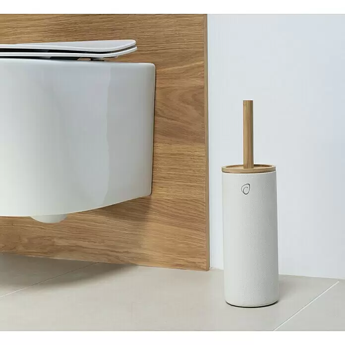 Camargue WC-Bürstengarnitur Vero - Bambus, Sand, Höhe: 38 cm - Hellgrau gesprenkelte Keramik-Toilettenbürste mit Bambusgriff neben einem weißen wandhängenden WC und Holzpaneel.