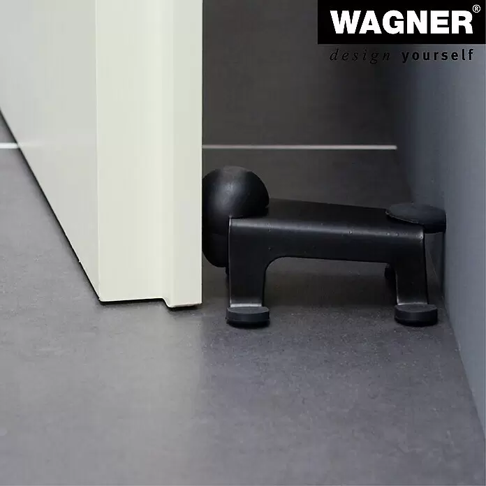 Wagner System Bodentürstopper EH5208 - L x B x H: 59 x 106 x 71 mm, Stahl, Schwarz - Schwarzer Türstopper aus Metall mit Gummipuffern, der eine weiße Tür offen hält.