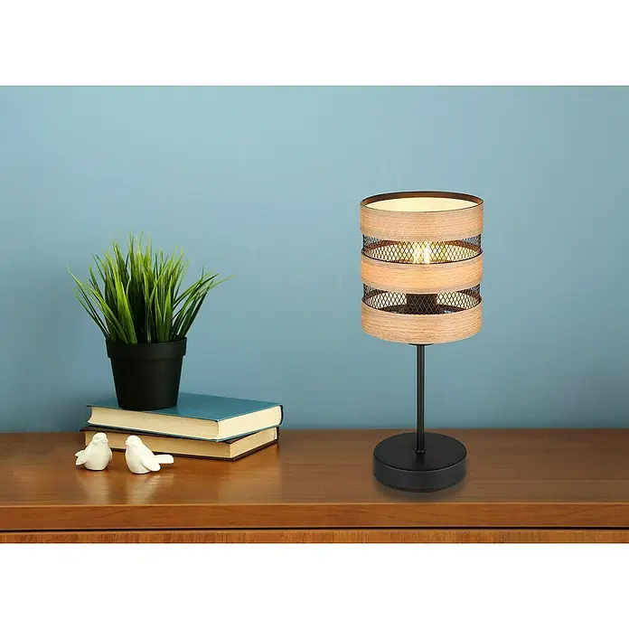 Globo Lámpara de sobremesa redonda Soeni - 40 W, Ø x Al: 15 x 33,5 cm, Negro/Madera, E27 - Lámpara de mesa con pantalla de madera y malla metálica, expuesta sobre una mesa de madera junto a libros y adornos.